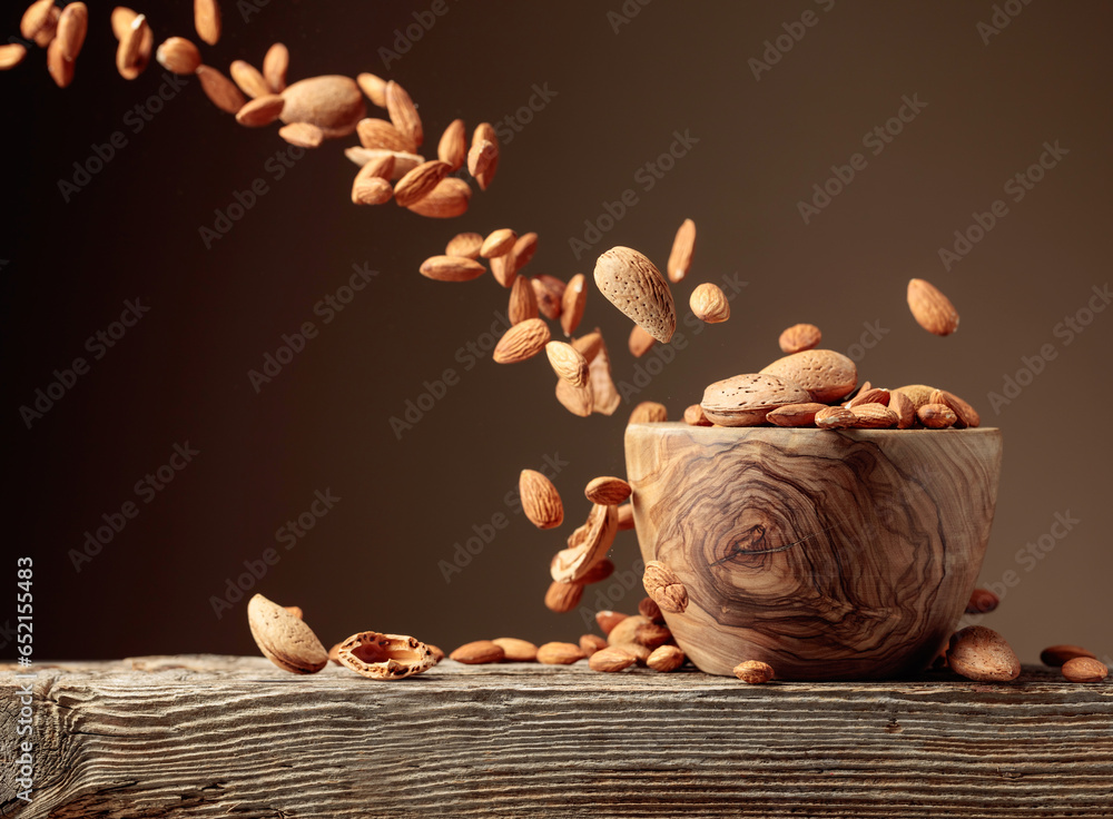 Almond is poured into a wooden bowl.