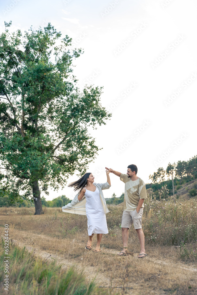 Playful and youthful adult man and woman having fun together in the meadow.