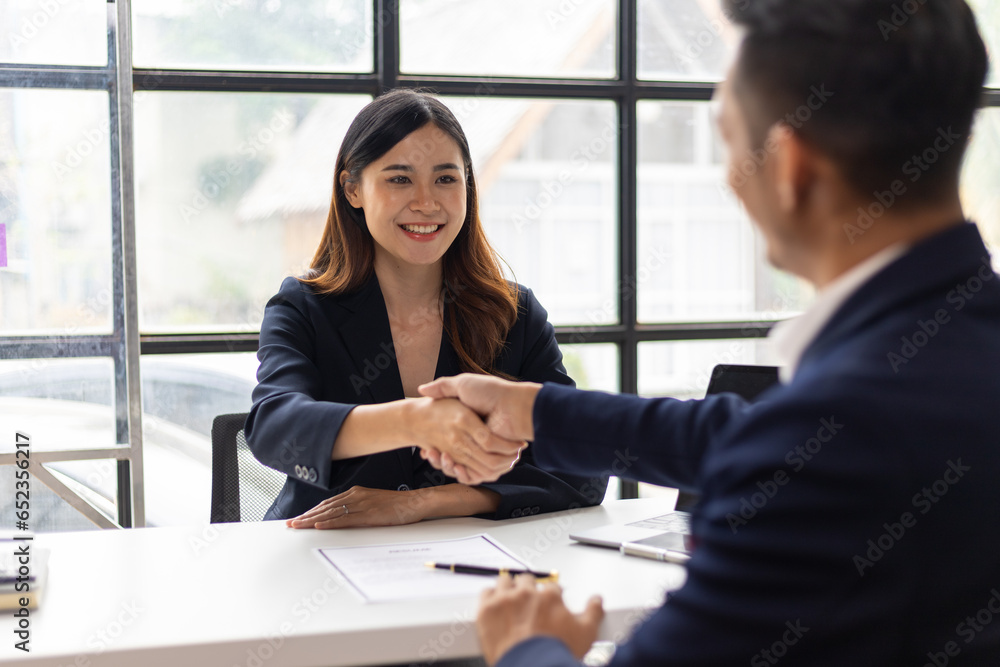 Business partners and colleagues shaking hands at work cooperation. Job applicant shaking hands with executives in office room at job interview.