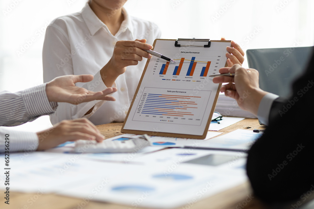 Business advisory meeting discussing analyzing company growth using business reports and financial charts. Brainstorming, analyzing strategies and planning investments.