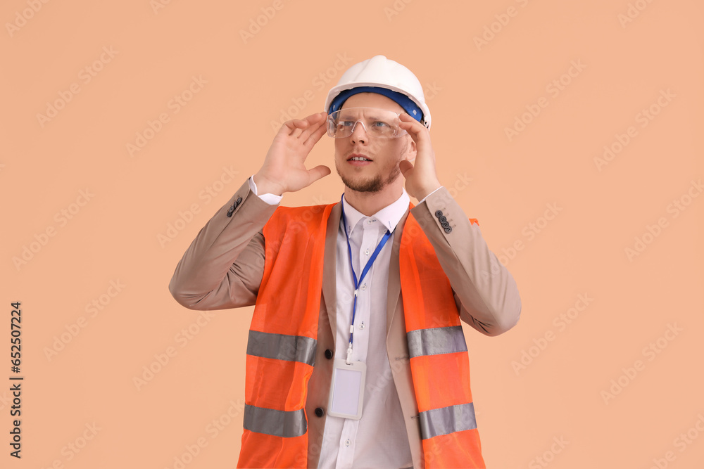 Male architect in vest on beige background