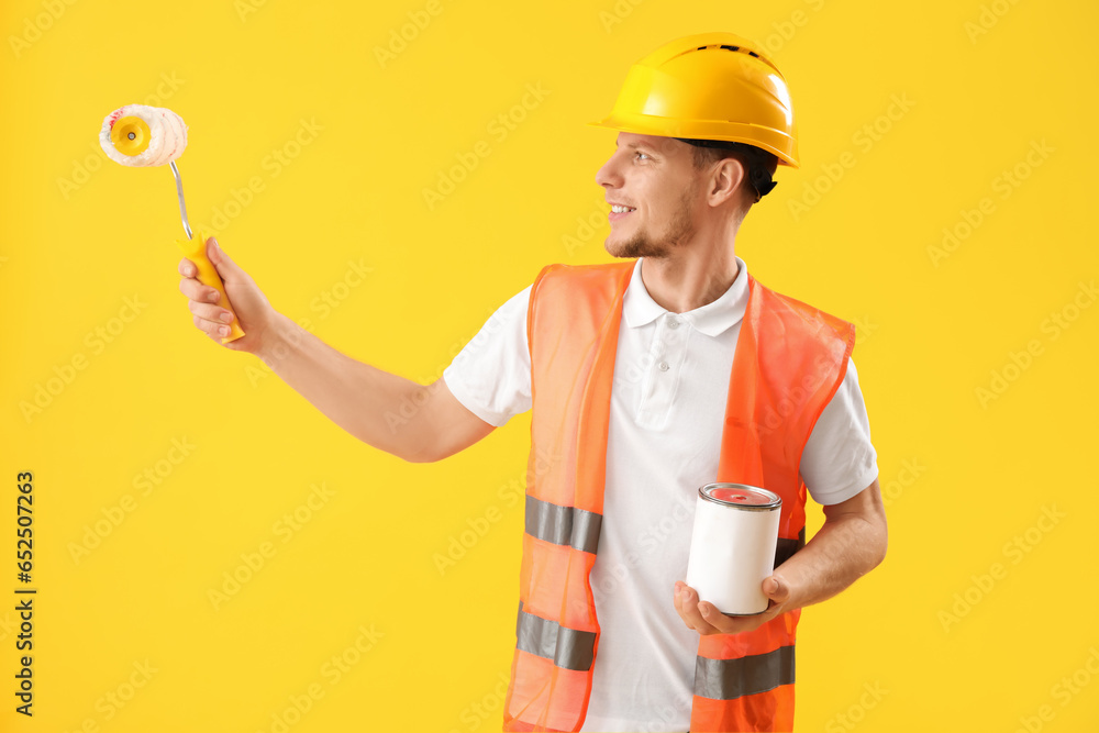 Male decorator on yellow background