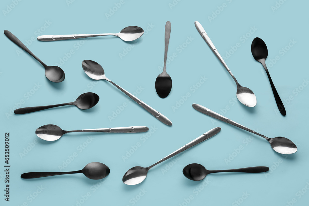 Stainless steel spoons on blue background