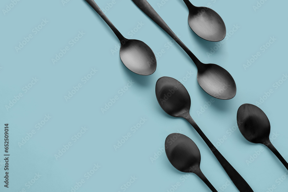 Black spoons on blue background