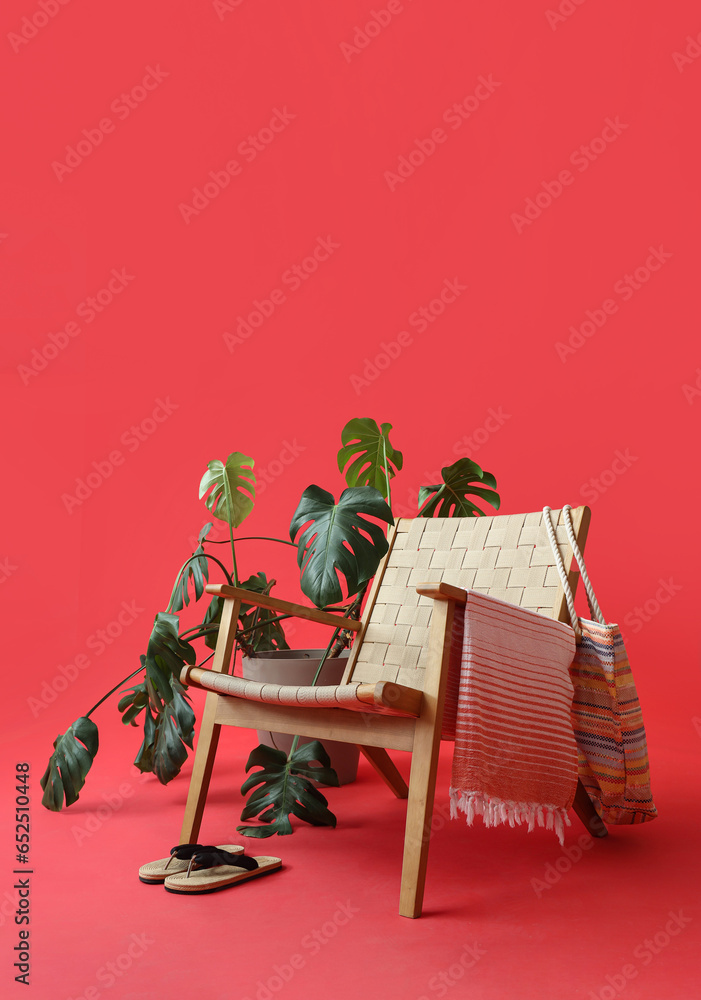 Composition with chair, plant and beach accessories on red background. Summer vacation concept