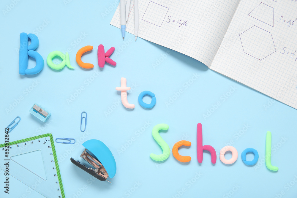 Text BACK TO SCHOOL and stationery on light blue background