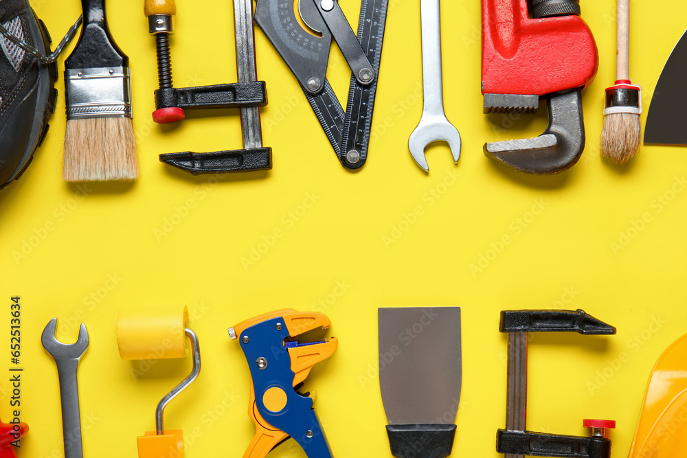 Frame made of different construction tools on yellow background