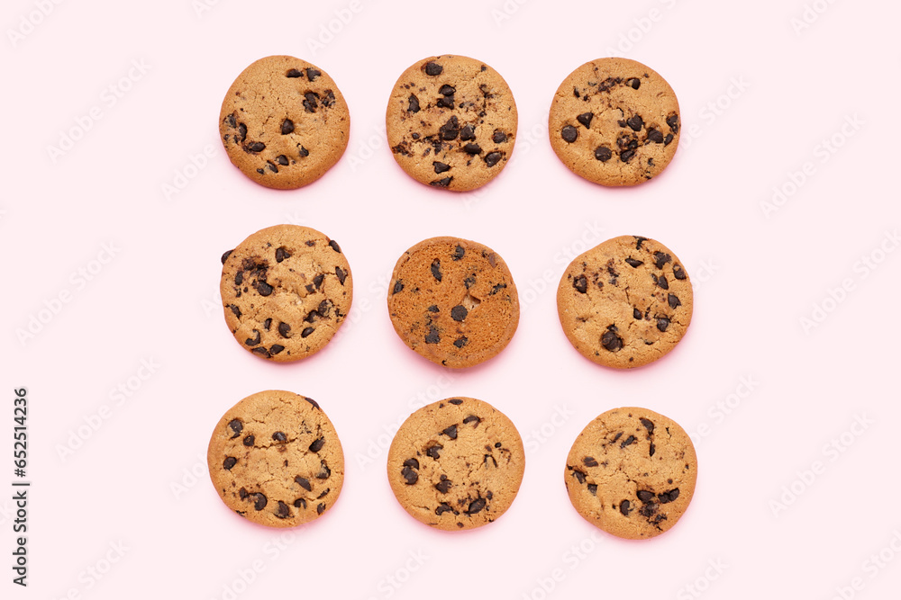 Tasty cookies with chocolate chips on pink background