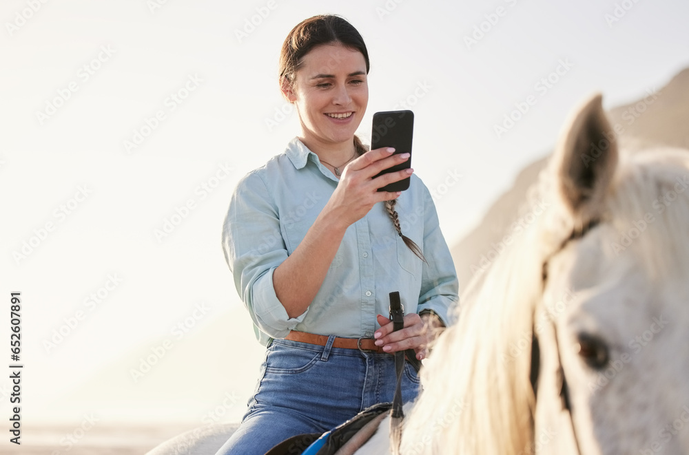 Horse riding, phone and woman on beach with pet for travel using social media, website and web for chatting. Texting, smile and happy person or rider with animal on vacation or holiday at sunrise