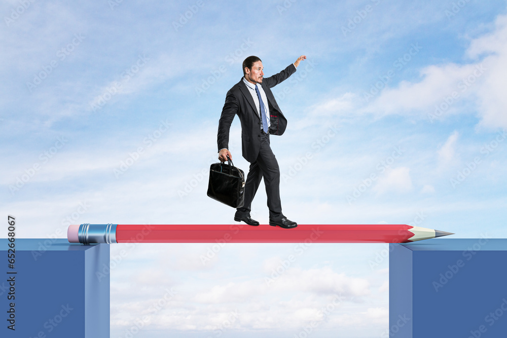 Attractive young european man crossing pencil bridge on sky background. Career problem and gap concept.