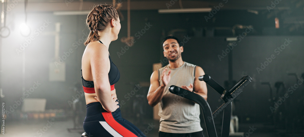 Woman, cycling and personal trainer in high five, motivation or fitness workout, exercise and training at gym. Man coaching female person on bicycle, machine or equipment in cardio at health club