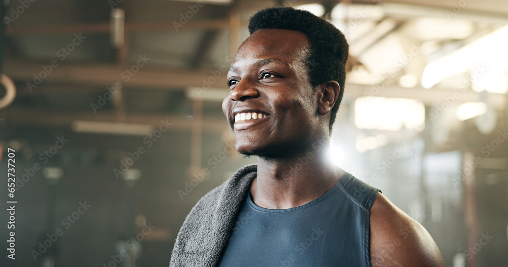 Smile, fitness and face of black man at a gym for training, exercise and athletics routine. Happy, mindset and African male personal trainer at sports studio for workout, progress and body challenge