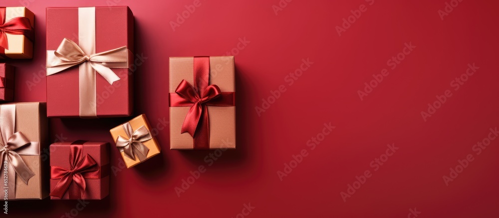 Arranged gift boxes with ribbons seen from above on a red tabletop