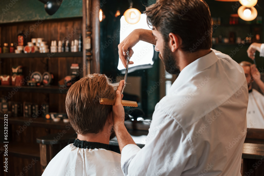 Getting haircut. Man is visiting modern barber shop. Modern style