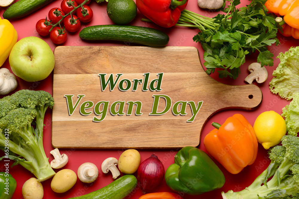 Greeting card for World Vegan Day with many vegetables on red background