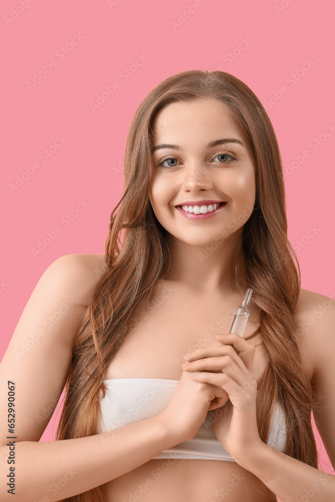 Beautiful young woman with ampule on pink background. Skin care concept