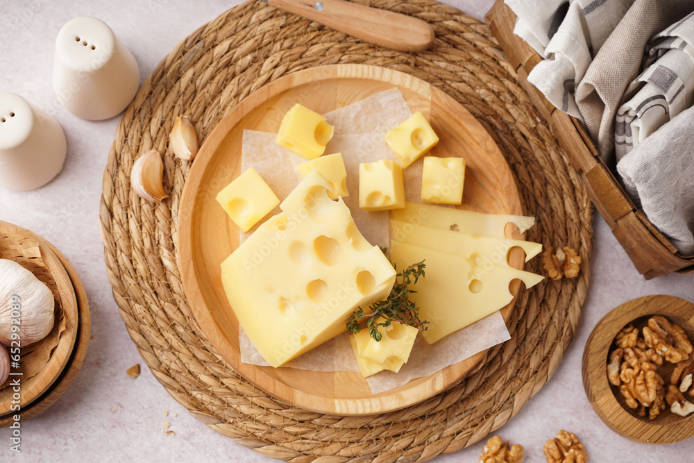 Plate with pieces of Swiss cheese and walnut on white background