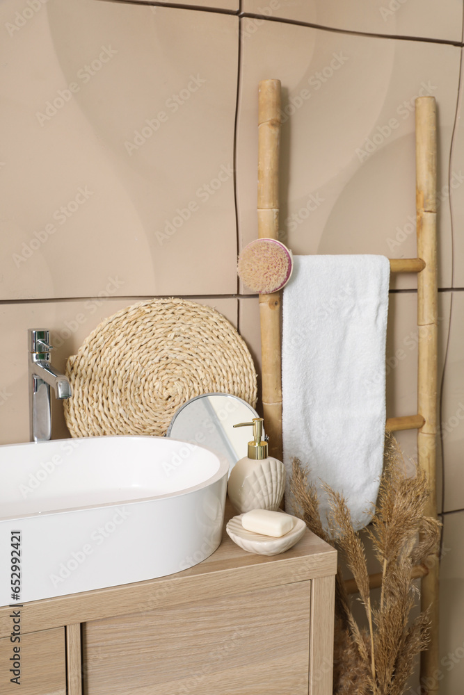 Sink bowl with bath accessories on table in bathroom