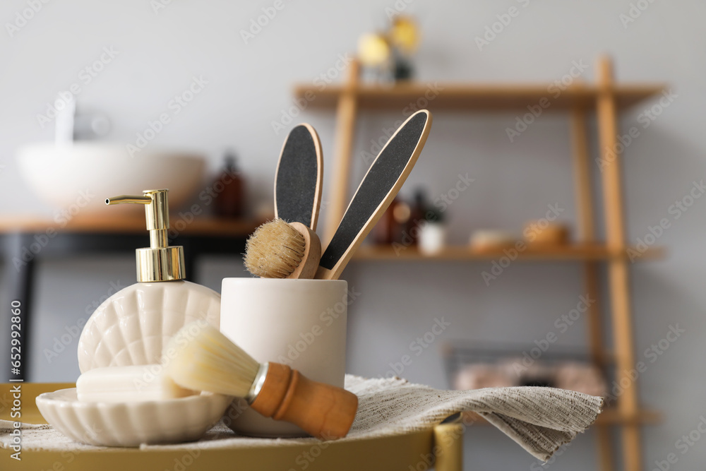 Soap bar, dispenser, shaving brush and bath accessories on table in bathroom, closeup