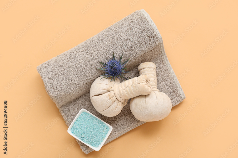 Clean towel, spa herbal bags and sea salt on color background