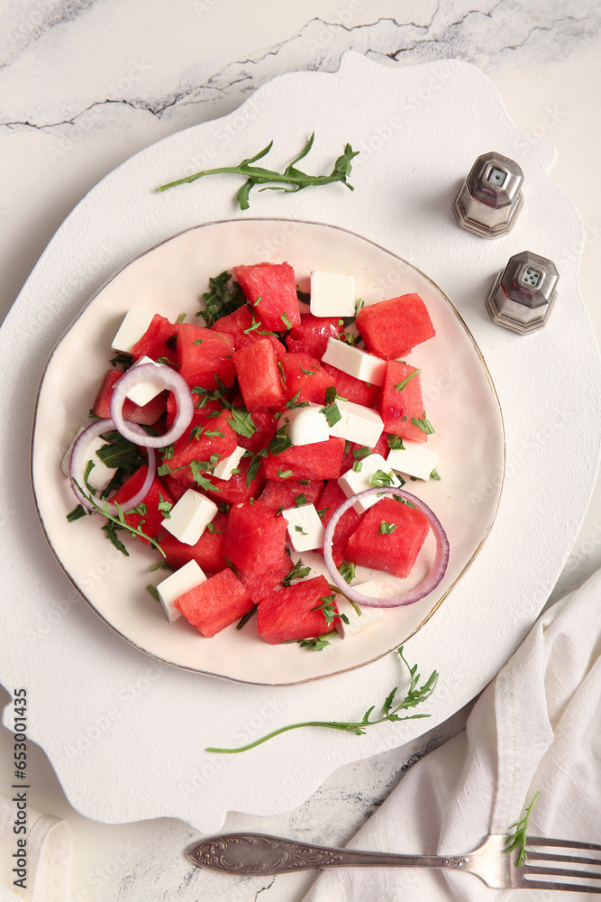 Plate of tasty watermelon salad on white marble background