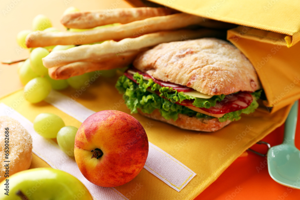 Lunch box bag with different tasty food on orange background