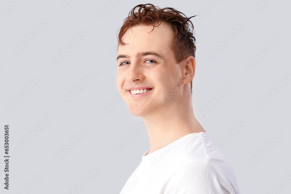 Young man with wet hair on light background