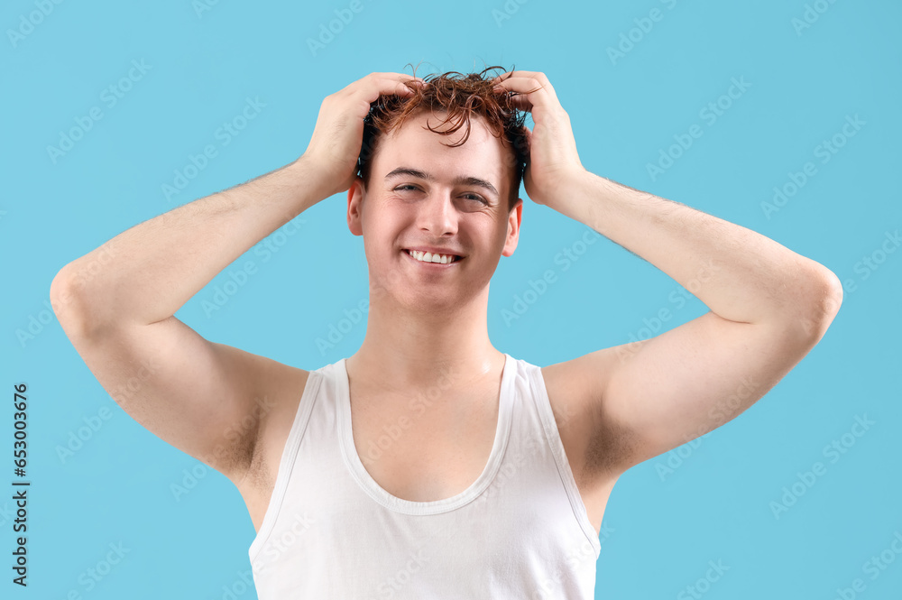 Young man with wet hair on light blue background