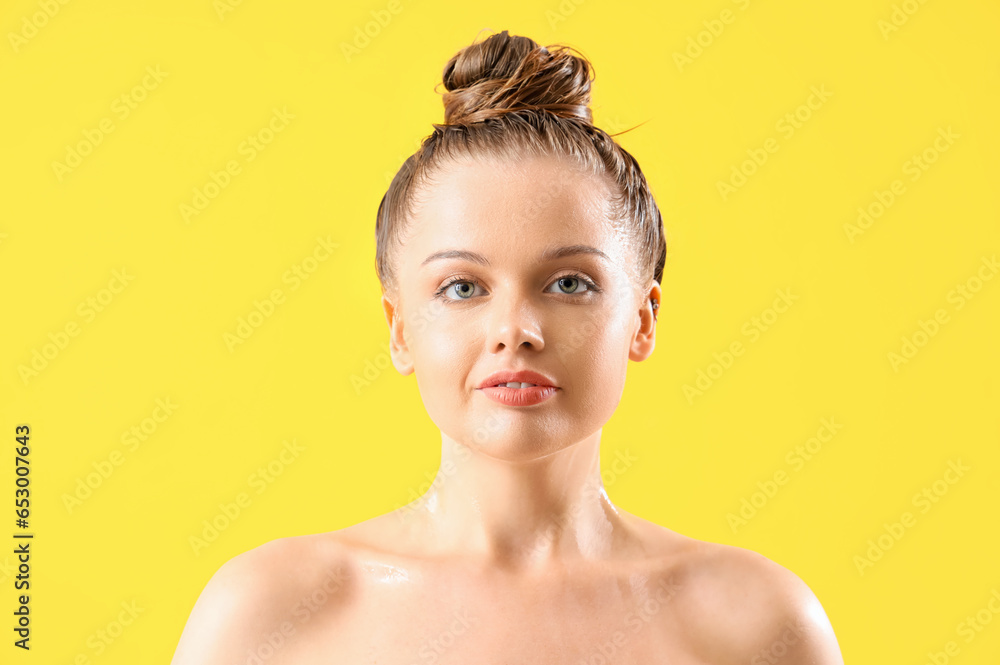 Young woman after washing hair on yellow background, closeup