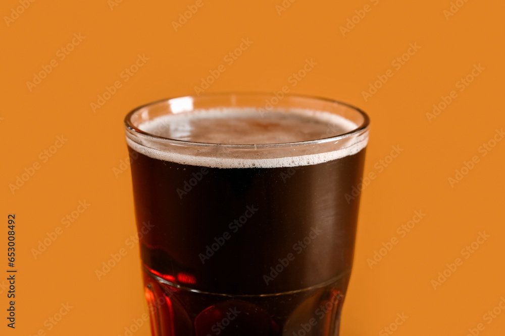 Glass of tasty kvass on orange background