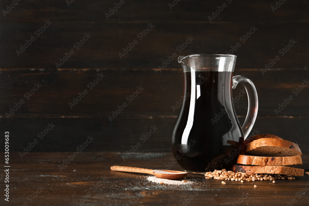 Jug of tasty kvass and ingredients on wooden background