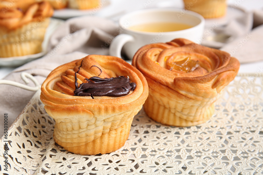 Tray of tasty cruffins with chocolate and jam on table