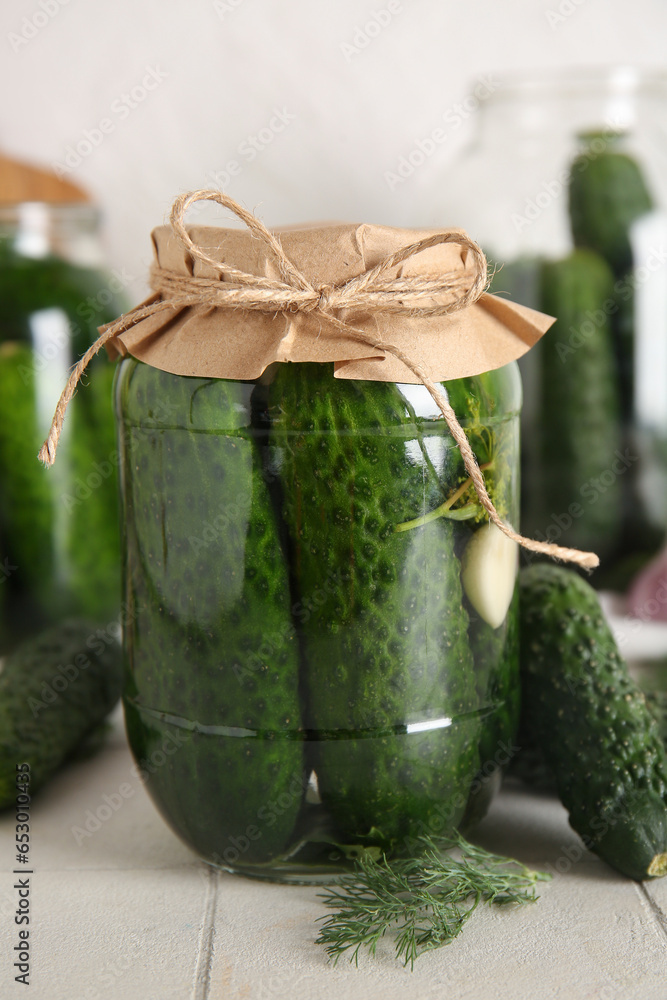 Jar with canned cucumbers on table