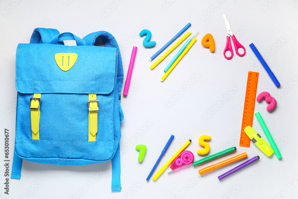 Stylish school backpack with different stationery on grey background