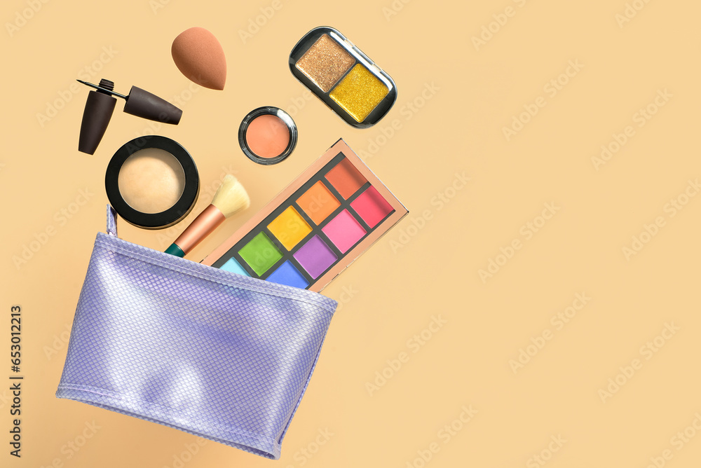 Cosmetic bag with different makeup products on yellow background