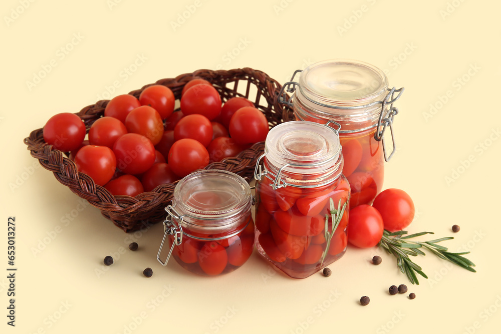 Jars of pickled tomatoes with rosemary and peppercorn on yellow background