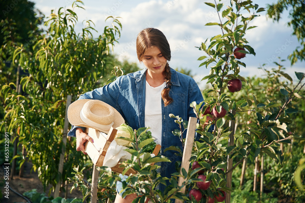 Working at daytime. Beautiful young woman is gardening