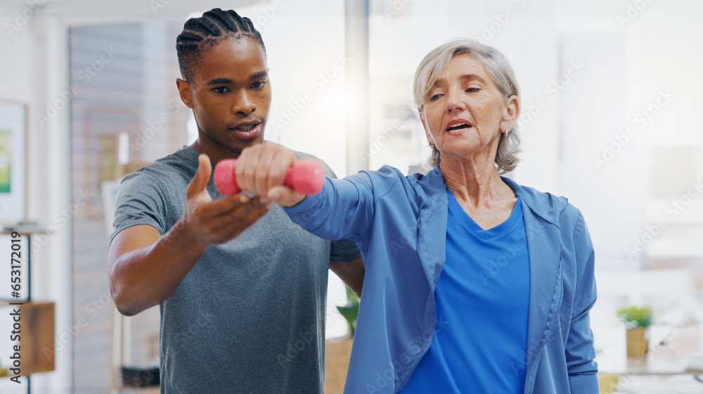 Senior woman, nurse and rehabilitation with dumbbells exercise in a nursing home for fitness. Elderly patient with a therapist man for healing, health and physiotherapy for arms, muscle and body