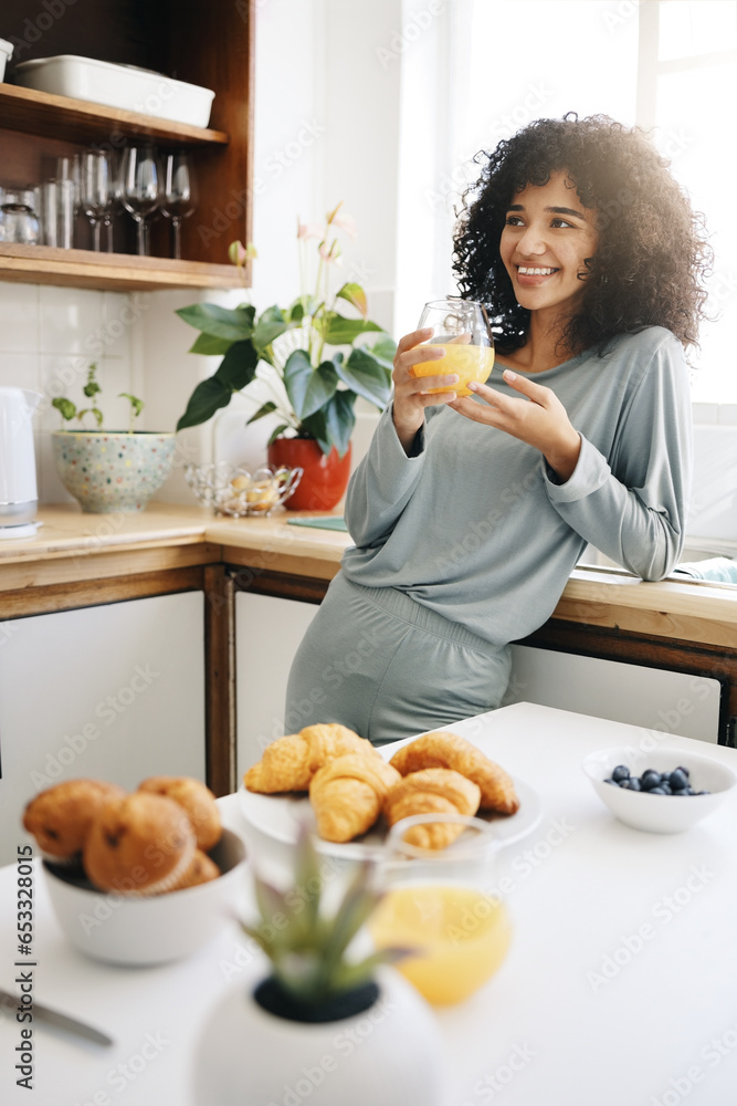 Woman, smile and thinking with orange juice in kitchen for breakfast, nutrition and vitamin c in the morning. Food, person and happiness with idea and drink with pajamas or natural face for wellness