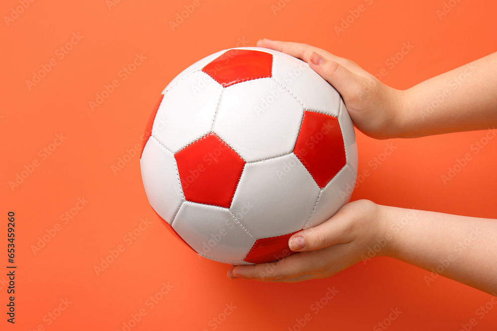 Hands with soccer ball on orange background