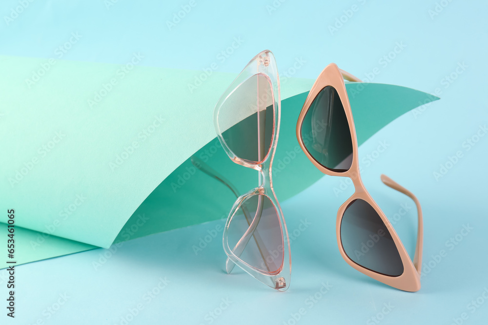 Stylish sunglasses on color background