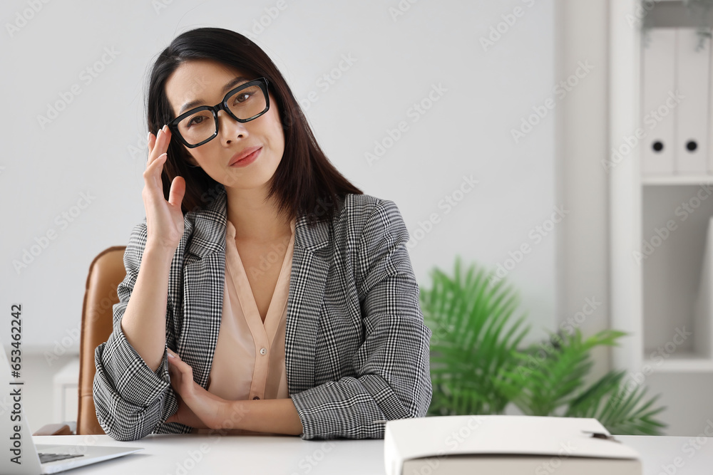 Beautiful Asian businesswoman in stylish eyeglasses in office