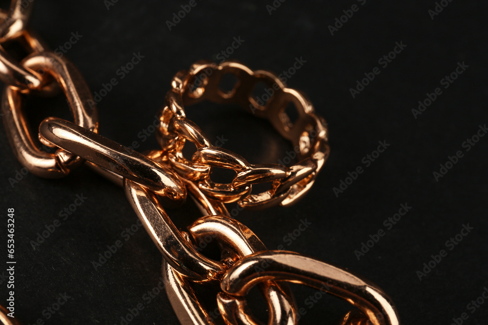 Beautiful chain bracelet and ring on black background