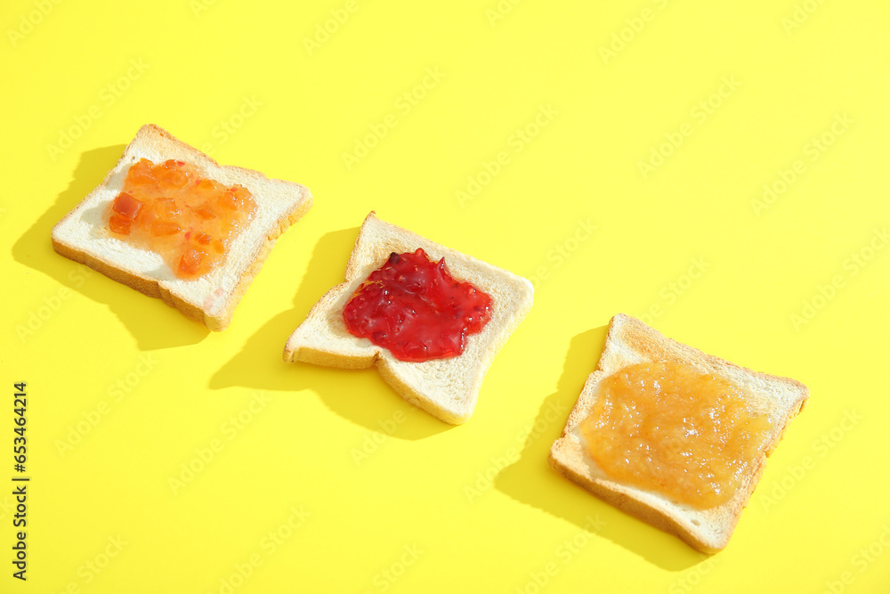 Tasty toasts with jams on yellow background