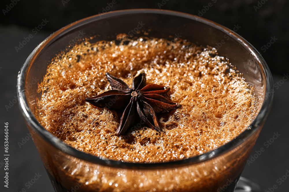 Glass of delicious espresso with star anise on dark background, closeup