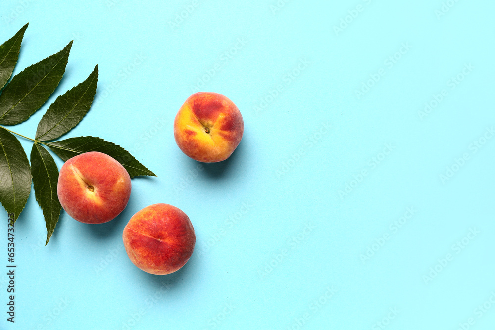 Sweet peaches and leaves on blue background