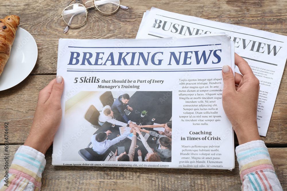 Woman reading newspaper on wooden background