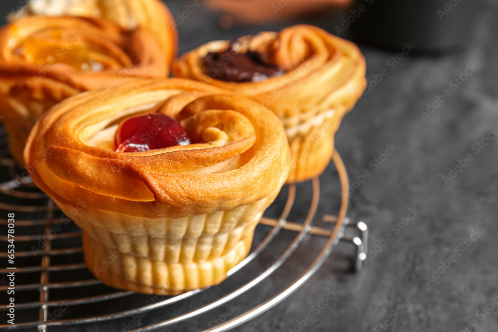 Grid of tasty cruffins with jam on black background