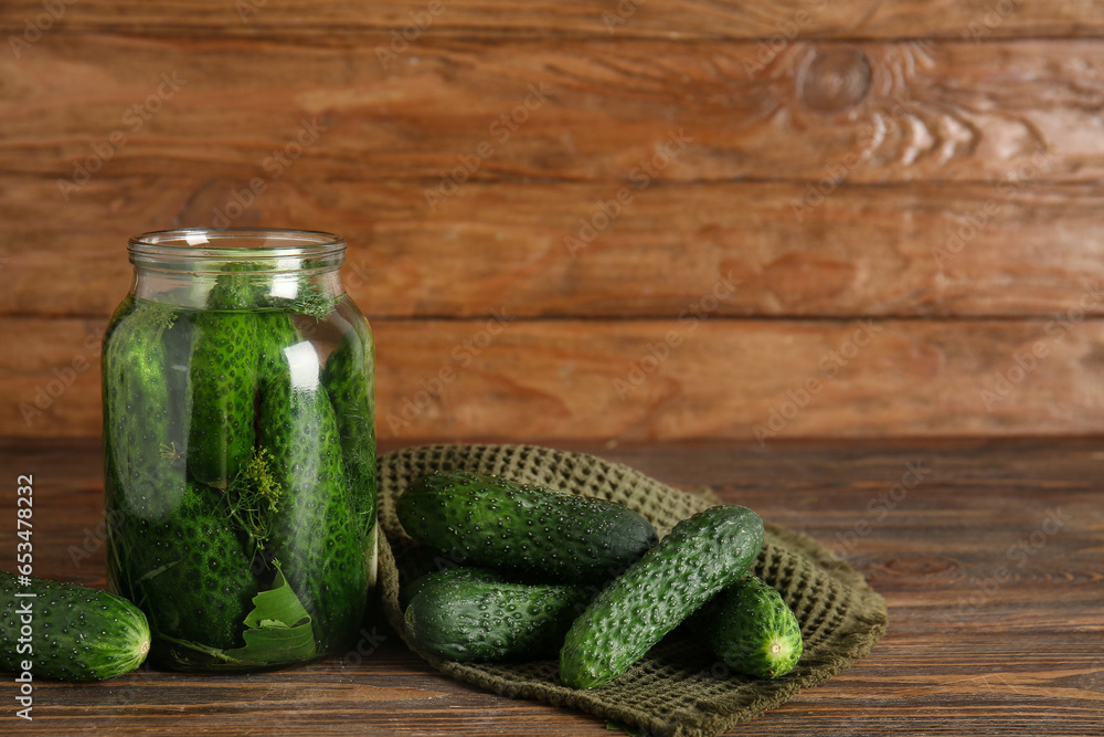 Jar with fresh cucumbers for canning on wooden background