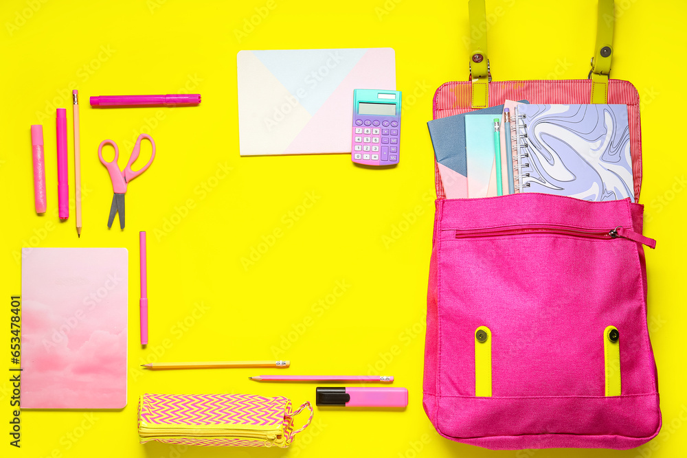 Frame made of school backpack and different stationery on yellow background